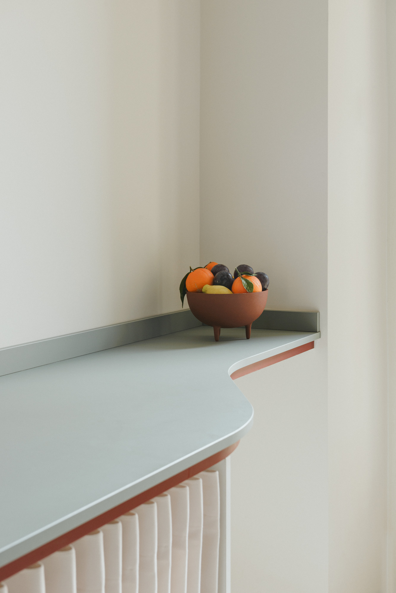 Modern sage green shelf with red details.